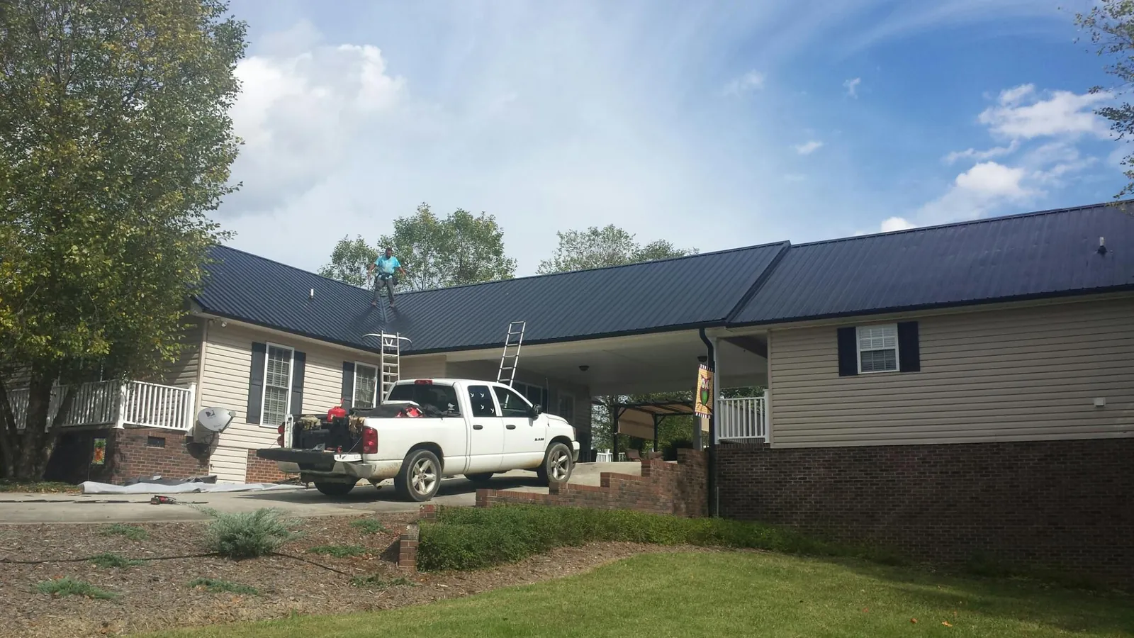 Black metal roof over a home and attached breezeway with ladders set in Abercrombie