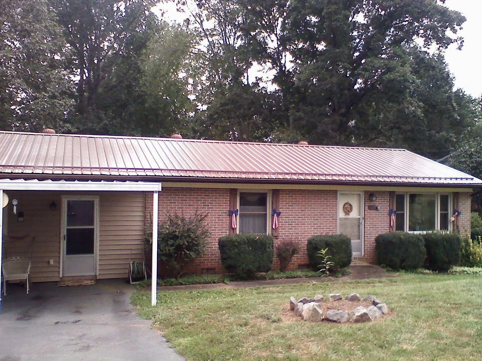 Bronze metal roof and carport on a brick ranch home — Roof Repair work by our crew in Abercrombie